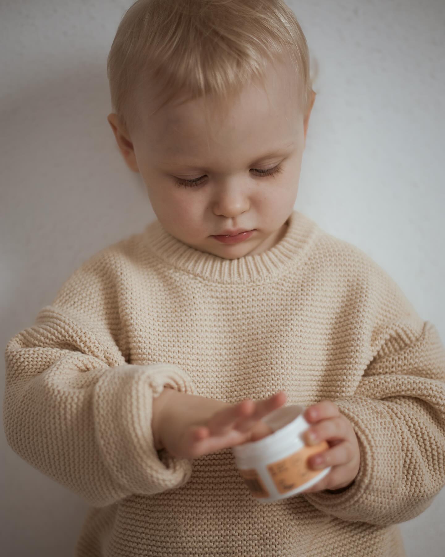 Dziecko używające naturalny krem do twarzy dla dzieci z hipoalergiczną formułą w bezpiecznym otoczeniu.